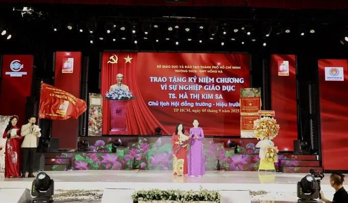 Dr. Ha Thi Kim Sa, Chair of the School Council and Principal of Hong Ha Secondary and High School (L) is awarded the Medal for the Cause of Education. 12.jpg