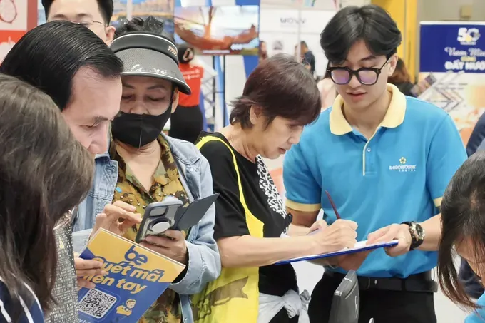 Visitors booking tours at the Saigontourist Travel booth during the expo (Photo: SGGP) khach-mua-tour-sg-5859-841.jpg