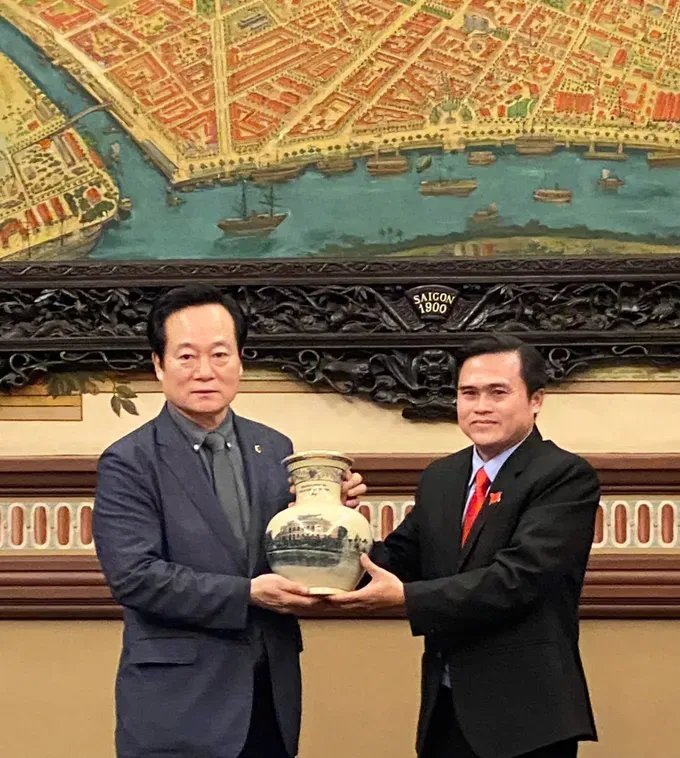 Mr. Cao Thanh Binh (R) offers a gift to Mr. Yoon Tae-han. (Photo: SGGP) z7017000696471-4f3847113f5931eebbb269e07811cb28-5327-6131.jpg