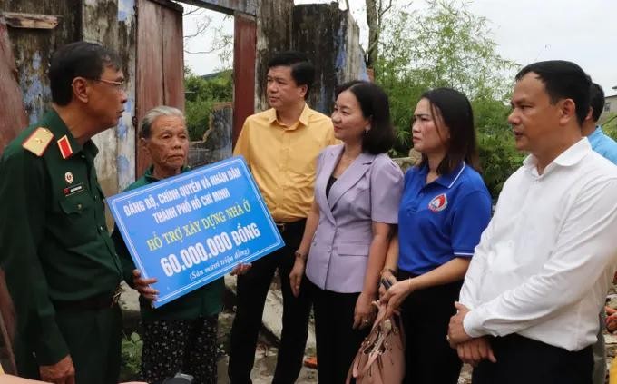 The delegation visits the home of Mrs. Tran Thi Phuong to provide VND60 million (US$2,275) in financial aid to help her family repair their house, which had collapsed during the storm. (Photo: SGGP) hotro5.jpg