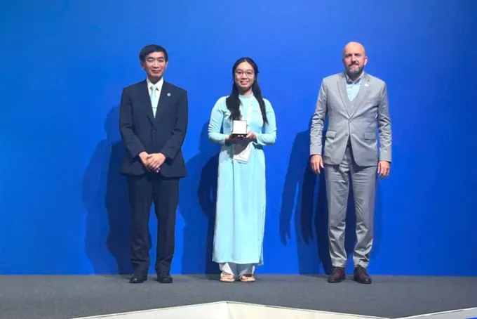 Mr. Masahiko Metoki, Director General of the UPU, and Mr. Marjan Osvald, Deputy Director General, present the Second Prize to Pham Doan Minh Khue. upu-02-189-8062.jpg