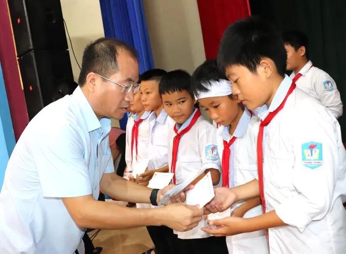 The delegation offers gifts to underprivileged students in Ha Tinh Province. (Photo: SGGP) hotro8.jpg