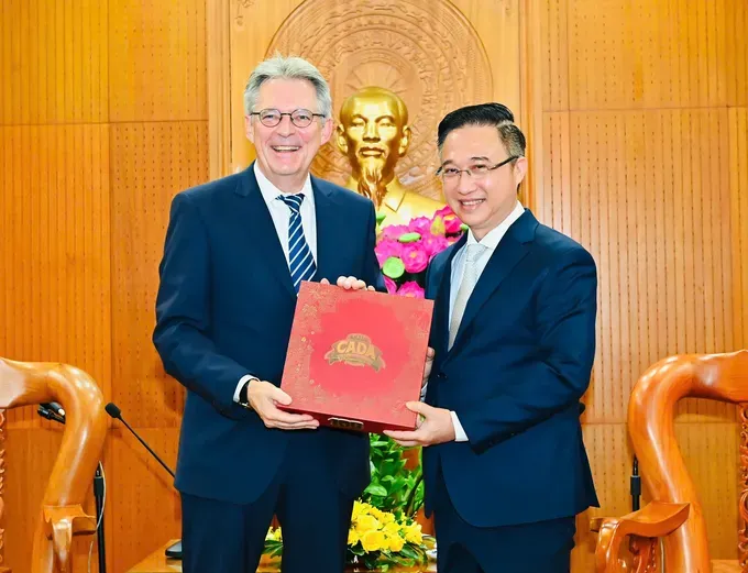 Vice Secretary of the Ho Chi Minh City Party Committee, Dang Minh Thong (R) offers a gift to Deputy Secretary General of the SPD, Achim Post. (Photo: SGGP) img-20251027-111814-8349-3676.jpg