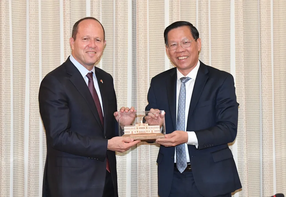 Chủ tịch UBND TPHCM Phan Văn Mãi tặng quà lưu niệm cho Bộ trưởng Kinh tế và Công nghiệp Israel. Ảnh: VIỆT DŨNG