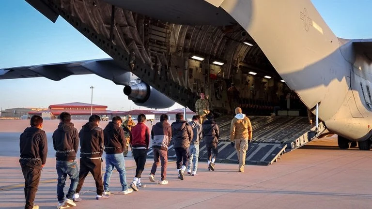 Người nhập cư bị trục xuất lên máy bay quân sự của Mỹ. Ảnh: SKY NEWS skynews-deportation-migrants_6809718.jpg