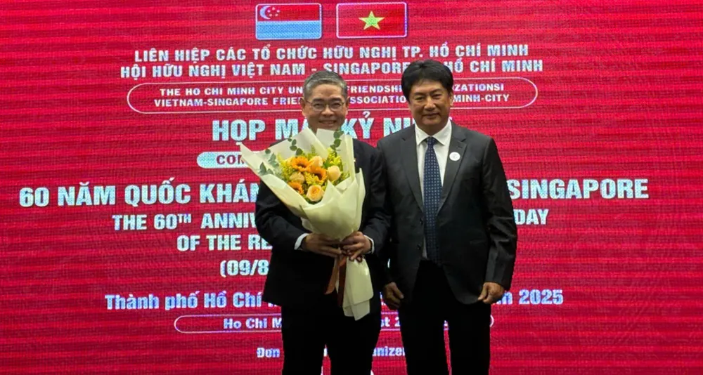 Chủ tịch VSFA tặng hoa Tổng Lãnh sự Singapore tại TPHCM Pang Te Cheng tại buổi họp mặt. Ảnh: THỤY VŨ IMG_20250822_112514.jpg