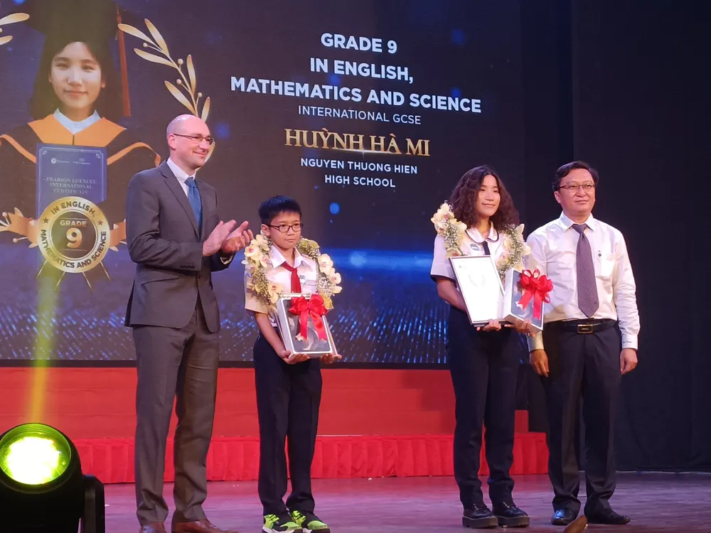 Phó Giám đốc Sở GD-ĐT TPHCM Nguyễn Bảo Quốc (bìa phải) trao bằng khen cho học sinh đạt thành tích cao qua kỳ thi chứng chỉ Pearson Edexcel