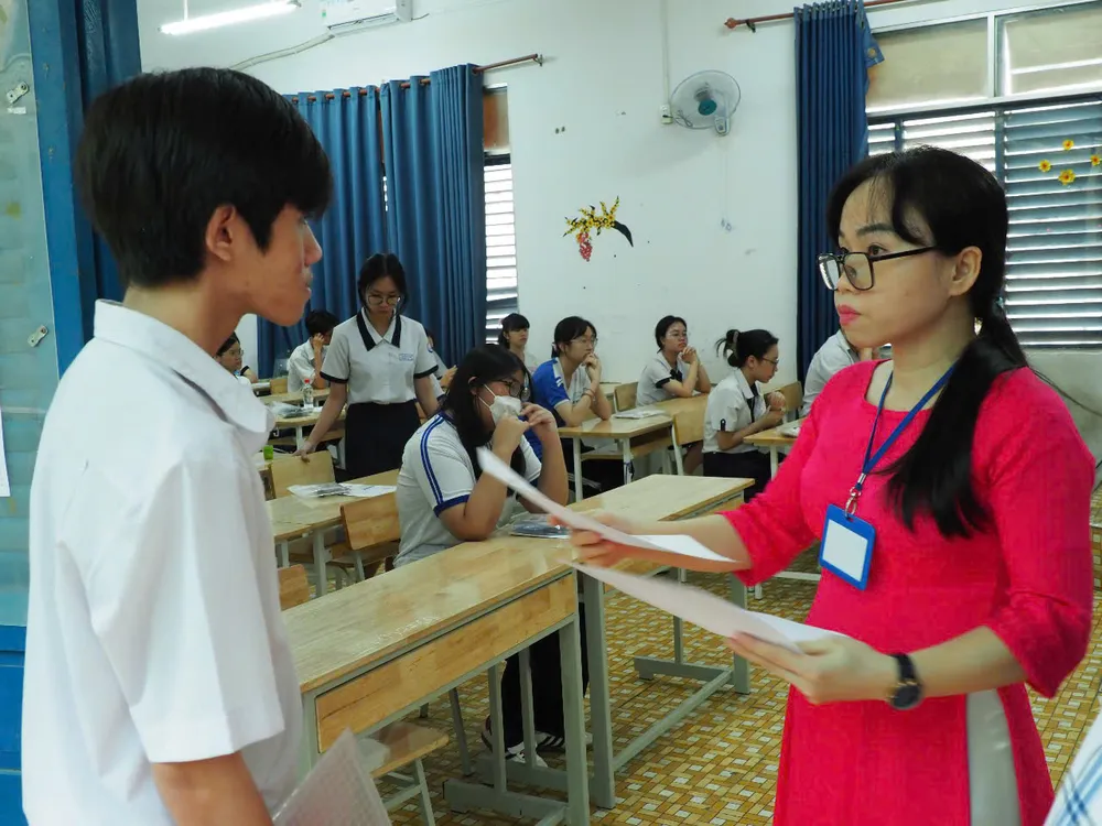 Cán bộ coi thi đọc tên thí sinh vào phòng thi. Ảnh: THU TÂM z6742662779438_c11fdf8d36c53eb616cdcfa29578fa1c.jpg