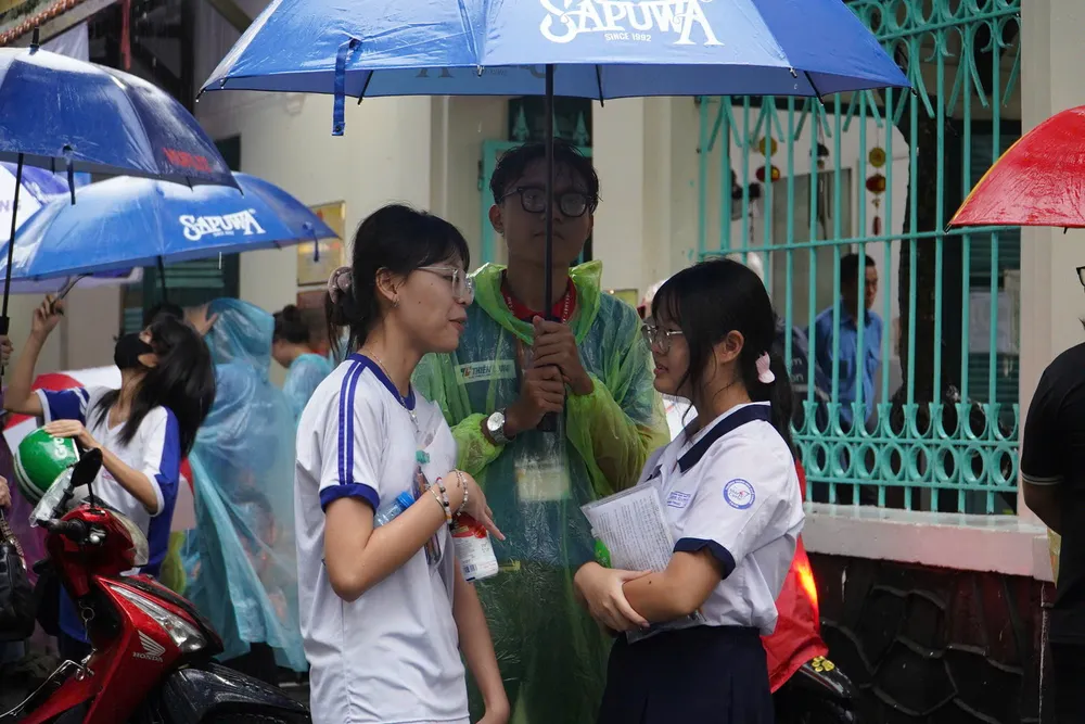 Thí sinh được lực lượng tình nguyện viên hỗ trợ dù tại điểm thi Trường THPT Lê Quý Đôn (quận 3). Ảnh: THU TÂM z6744641215939_aa570c82e453fcec6979fc5d17d50d05.jpg