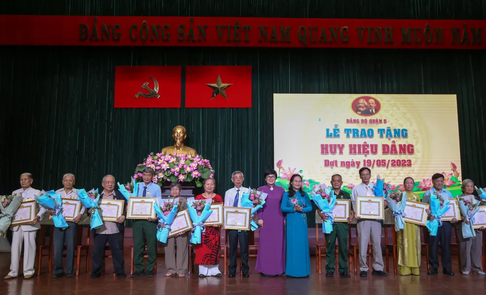 Chủ tịch HĐND TPHCM Nguyễn Thị Lệ và Chủ tịch UBND quận 5 Trương Minh Kiều trao Huy hiệu 60 năm tuổi Đảng và hoa chúc mừng các đảng viên. Ảnh: THẢO LÊ
