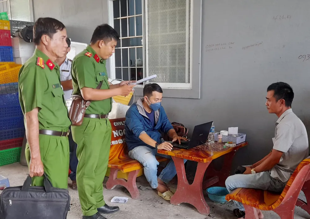 Lực lượng chức năng làm việc với chủ hộ kinh doanh. Ảnh: DUY ANH