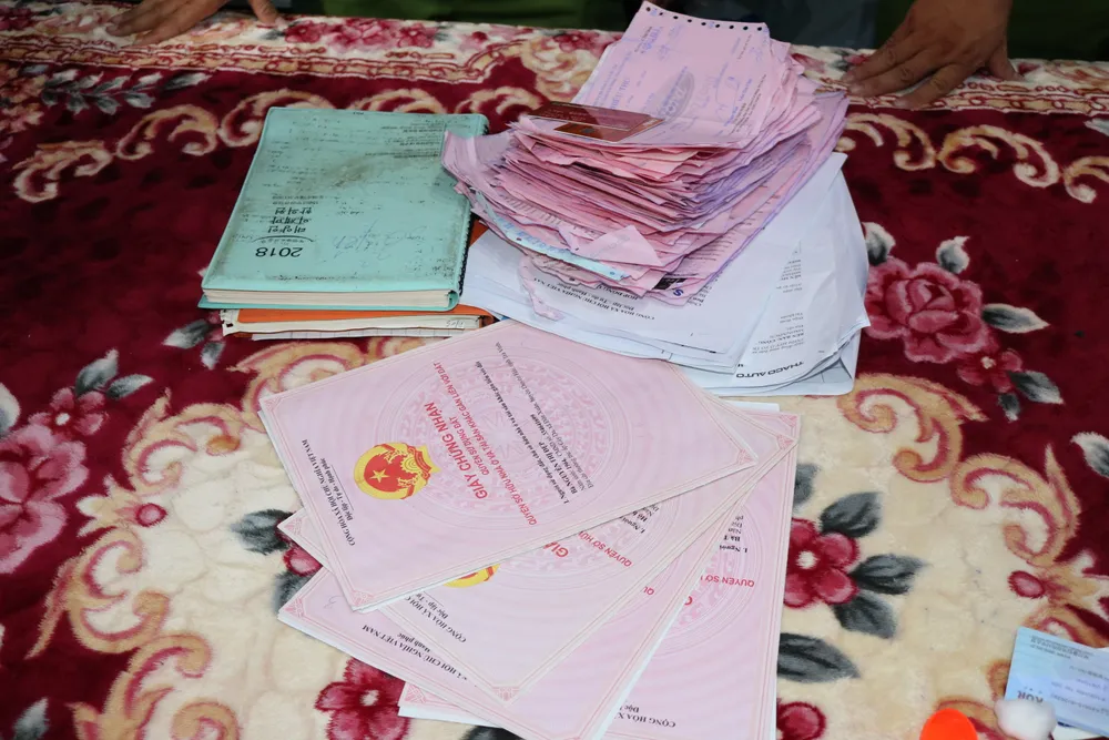 Tài liệu liên quan thu giữ tại nhà bà Đẹp. Ảnh: PHẠM HƠN Tài liệu liên quan thu giữ tại nhà bà Đẹp. Ảnh: PHẠM HƠN