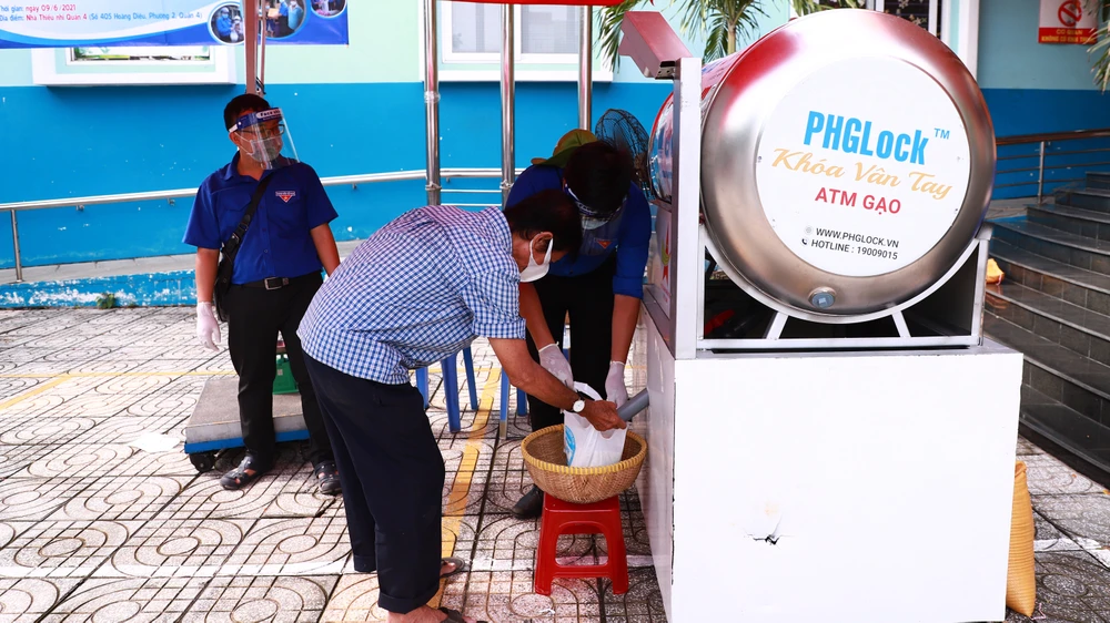 Người dân khó khăn nhận gạo từ máy ATM gạo