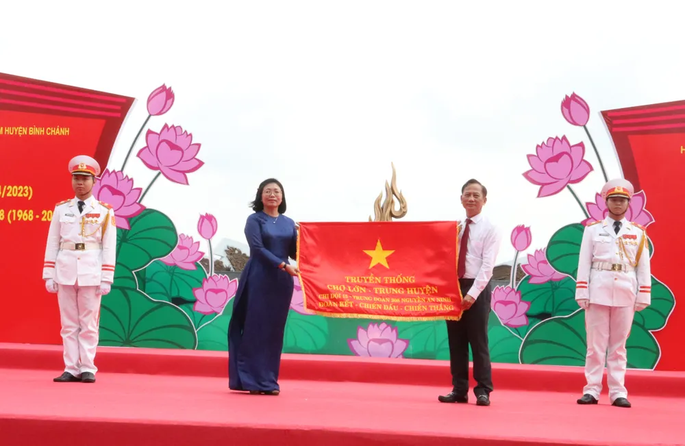 Bí thư Huyện ủy huyện Bình Chánh Trần Văn Nam trao cờ truyền thống đến Bí thư Quận ủy quận 5 Huỳnh Ngọc Nữ Phương Hồng - đơn vị tổ chức họp mặt vào năm tiếp theo