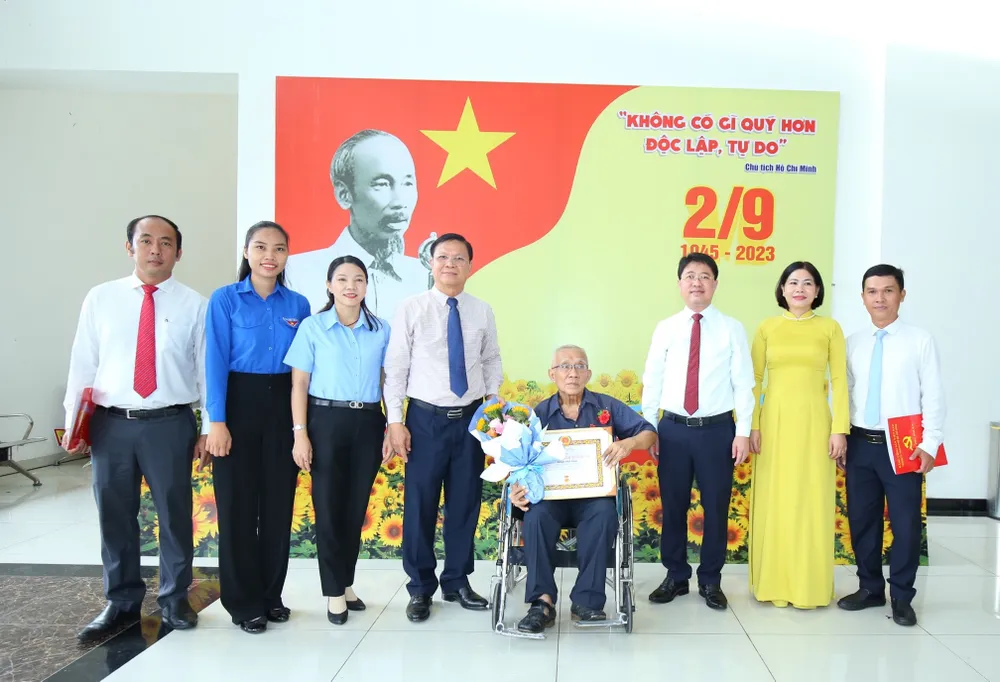 Bí thư Quận ủy quận Phú Nhuận Phạm Hồng Sơn chúc mừng đảng viên nhận Huy hiệu Đảng. Ảnh: BÙI HẢI