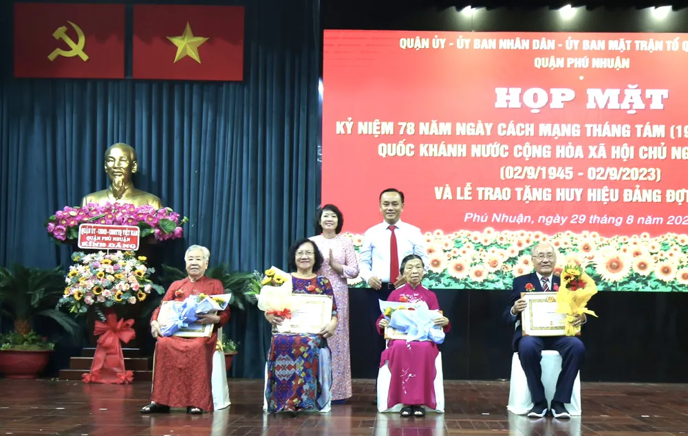 Chủ tịch UBND quận Phú Nhuận Nguyễn Đông Tùng chúc mừng các đảng viên nhận Huy hiệu Đảng. Ảnh: BÙI HẢI