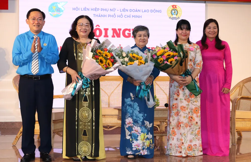 Phó Chủ tịch LĐLĐ TPHCM Phùng Thái Quang và Phó Chủ tịch Hội LHPN TPHCM Nguyễn Thị Ngọc Linh tặng hoa cảm ơn các nữ chủ nhà trọ chăm lo tốt người ở trọ