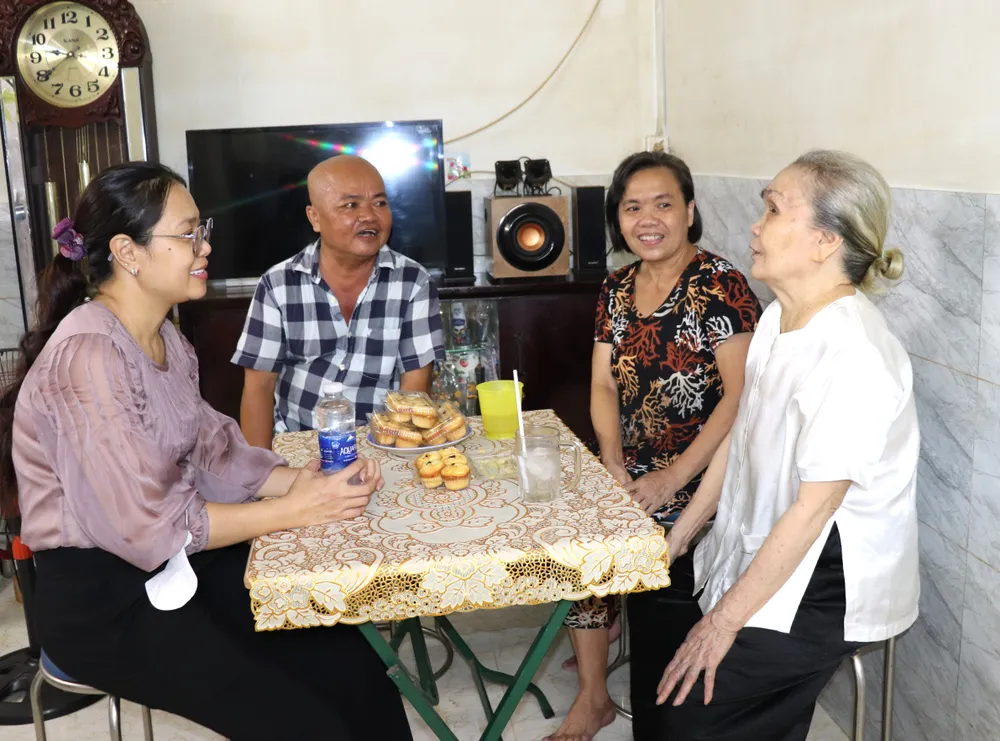 Bà Võ Thị Vĩnh (phải), hộ nghèo tại quận 4 cùng các con đón khách trong căn nhà mới được hỗ trợ sửa chữa.JPG