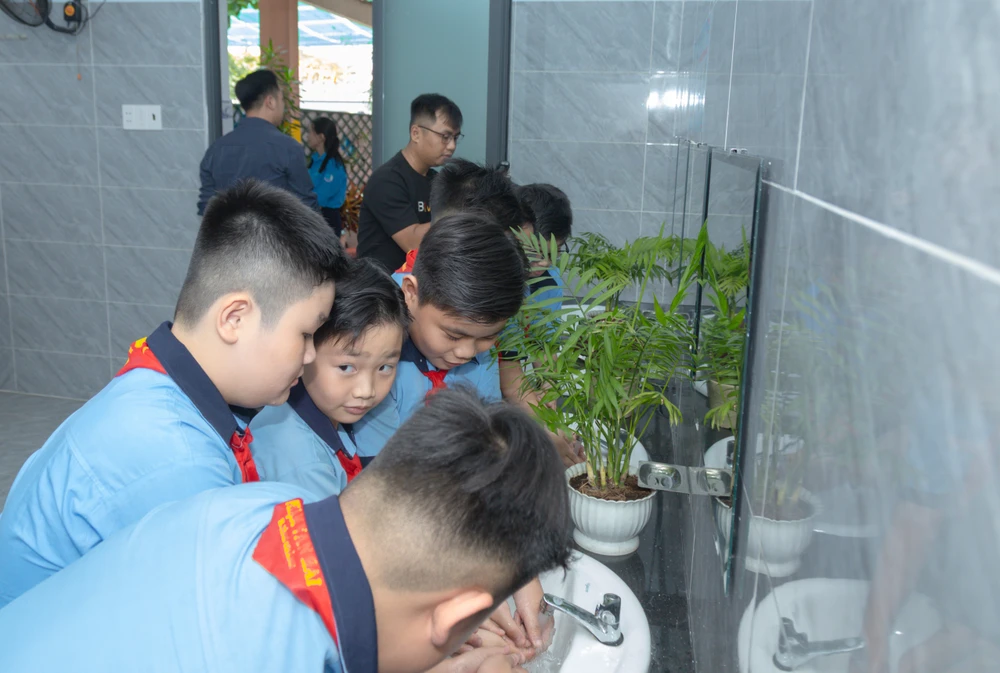 Học sinh Trường Tiểu học Phạm Văn Hai trong niềm vui được sử dụng nhà vệ sinh mới HInh 1.jpg
