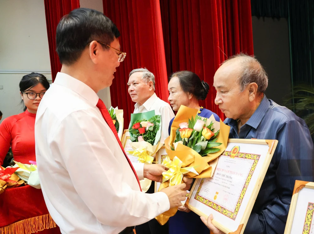 Bí thư Quận ủy quận Bình Thạnh Vũ Ngọc Tuất trao Huy hiệu Đảng đến các đảng viên Hinh BT 2.jpg
