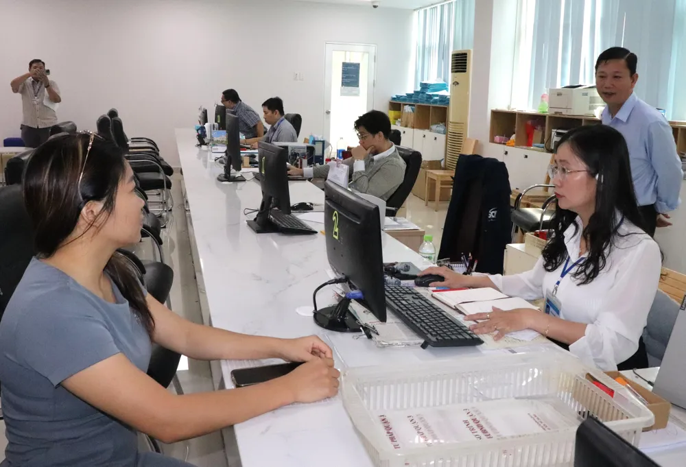 Bà Nguyễn Thị Bắc (bên trái) đến làm thủ tục tại phường Xuân Hòa. Ảnh: THÁI PHƯƠNG IMG_2757.JPG