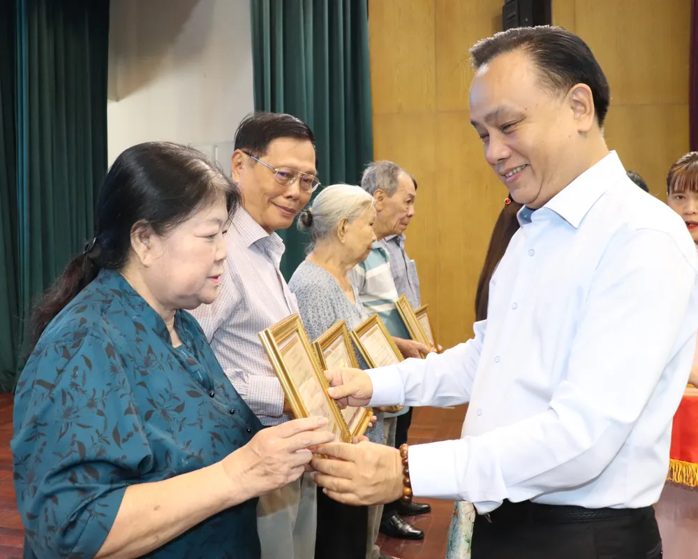 Bí thư Đảng ủy, Chủ tịch HĐND phường Phú Nhuận Nguyễn Đông Tùng trao giấy công nhận “Gia đình cách mạng gương mẫu” đến các gia đình. Ảnh: THÁI PHƯƠNG IMG_3210.JPG