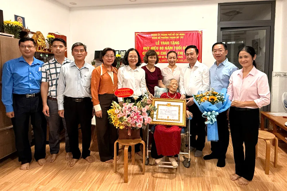 Phó Bí thư Thành ủy TPHCM Đặng Minh Thông trao Huy hiệu 80 năm tuổi Đảng đến đồng chí Trần Thị Quất Hinh 1.jpg