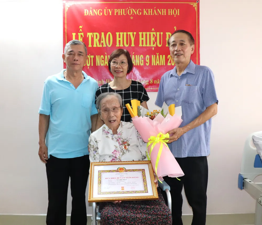 Đồng chí Lê Thị Nhàn trong niềm vui nhận Huy hiệu 80 năm tuổi Đảng bên con cháu IMG_4318.JPG