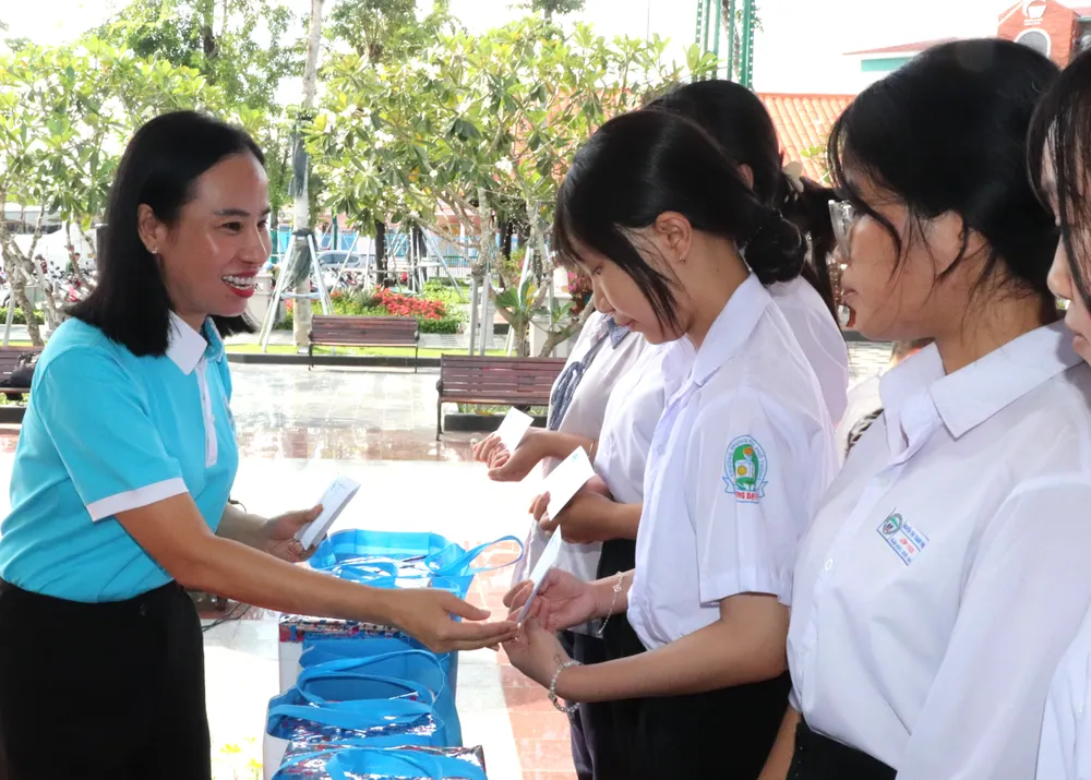 Chủ tịch Hội LHPN TPHCM Võ Ngọc Thanh Trúc trao học bổng đến học sinh. Ảnh: THÁI PHƯƠNG IMG_5021.JPG