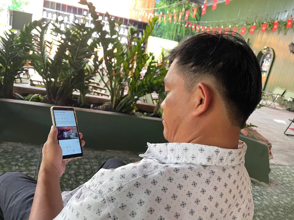Người dân phường Thủ Dầu Một đang xem thông tin về đại hội trên Báo Sài Gòn Giải Phóng. Ảnh: TÂM TRANG Bình Dương.jpg