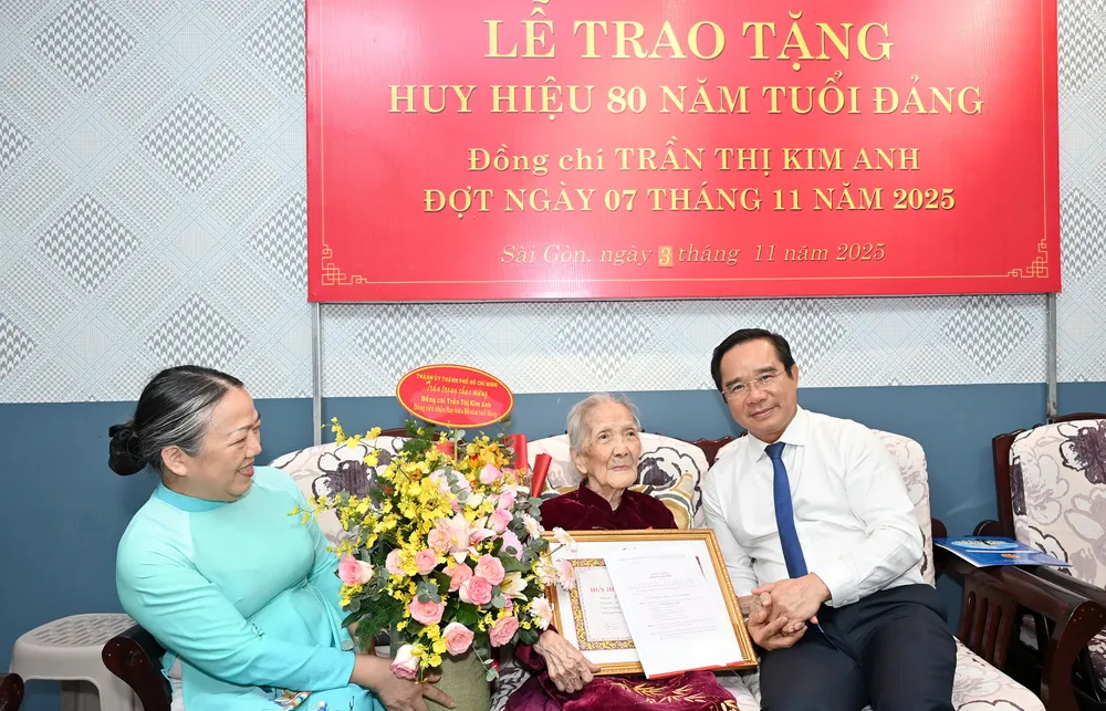 Đồng chí Nguyễn Văn Được trao Huy hiệu 80 năm tuổi Đảng đến đồng chí Trần Thị Kim Anh. Ảnh: MẠNH THẮNG