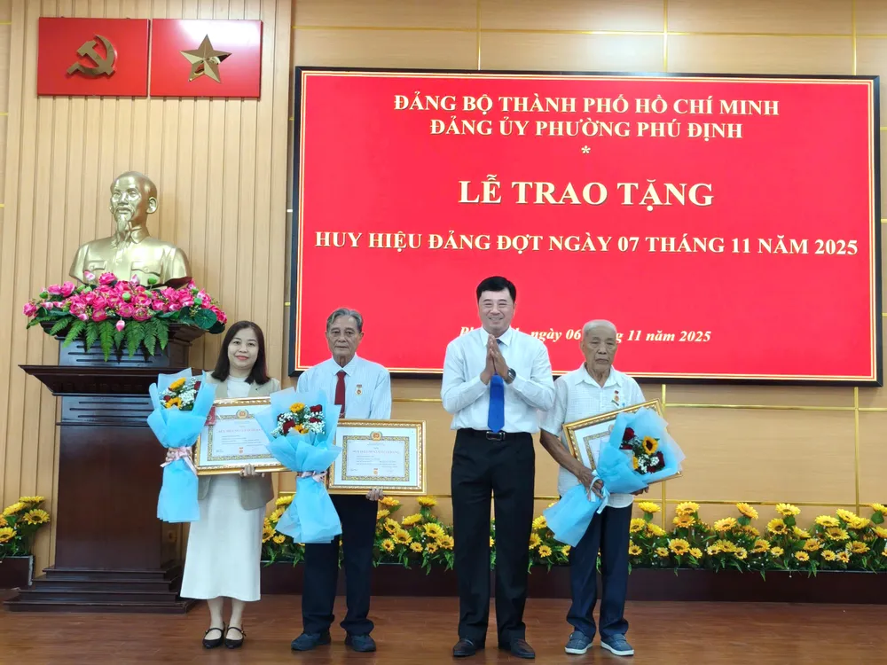 Bí thư Đảng ủy, Chủ tịch HĐND phường Phú Định Phạm Ngọc Muôn chúc mừng các đảng viên nhận Huy hiệu Đảng