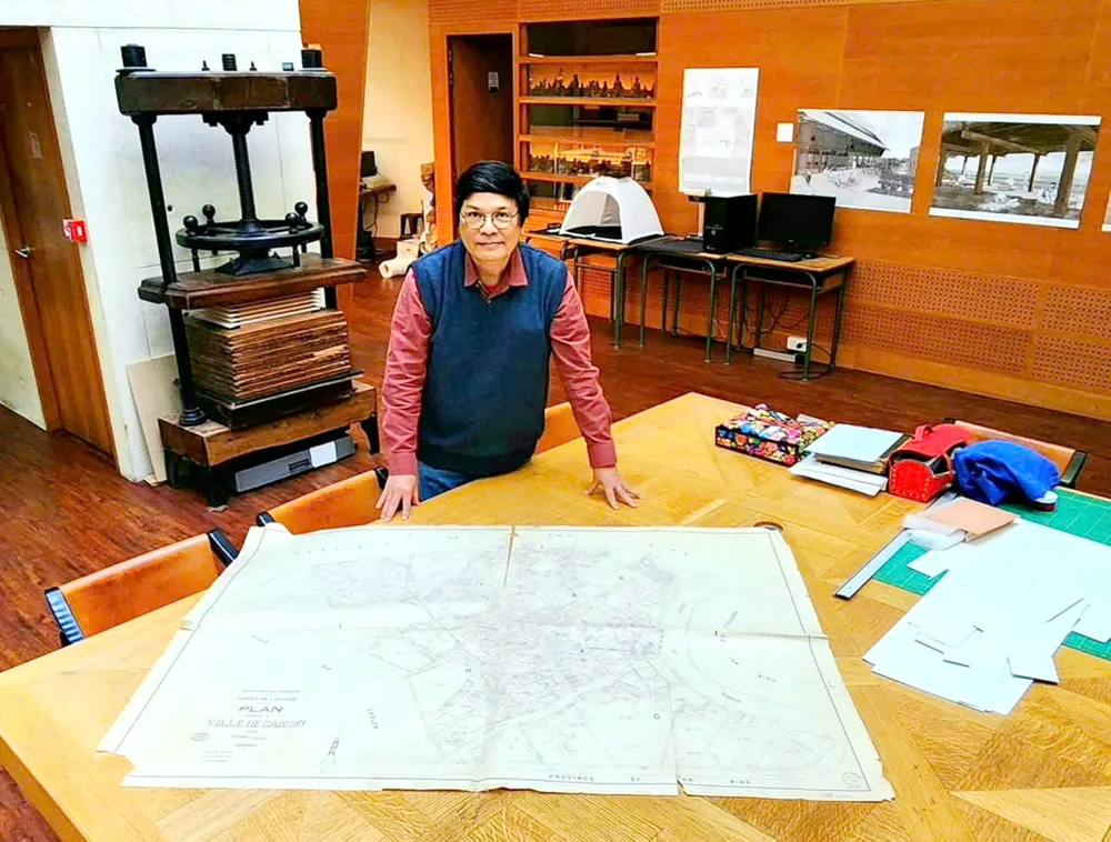 Forskaren Tran Huu Phuc Tien med en karta över Saigon på 1930-talet på École Française d'Extrême-Orient (EFEO) bibliotek i Paris i september 2024. Foto: NVCC CN3b.jpg