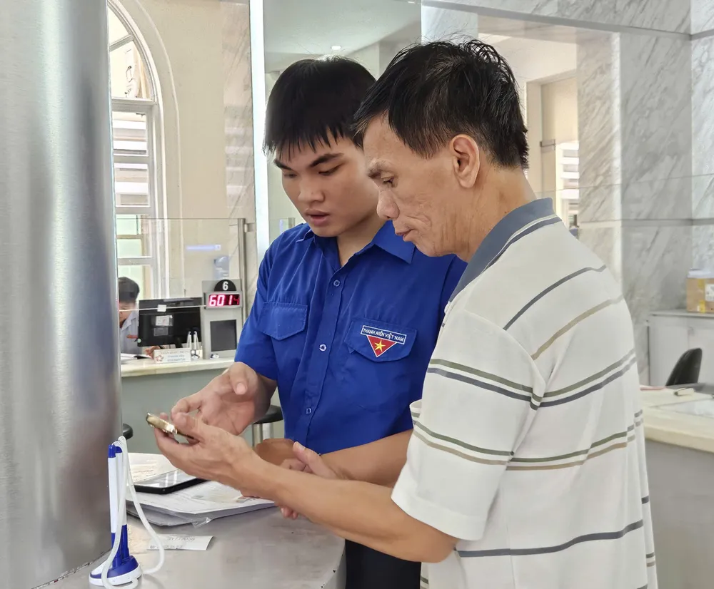 Unge frivillige veileder folk i å utføre administrative prosedyrer på nett ved Saigon Ward Public Administration Service Center. Foto: NGO BINH Q3b.jpg