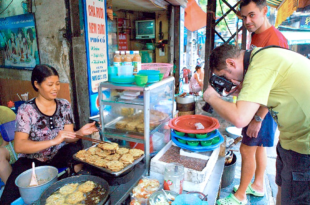 外国游客在了解越南街头美食。