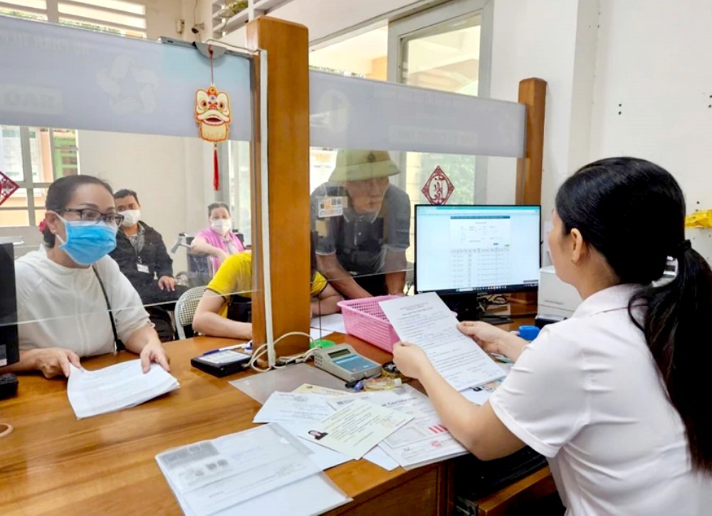 第十二郡安富东坊人委会公务员为人民解决卷宗。