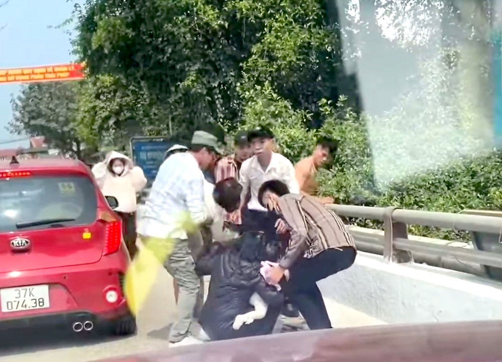民众试图阻止一名抱着两个孩子的妇女投河自尽。