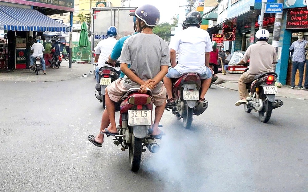 在街上行驶的摩托车正排放黑烟。