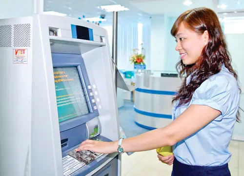 Khách hàng giao dịch tại ATM Eximbank. Ảnh: C.THĂNG