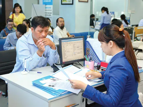 Khách hàng giao dịch tại Eximbank. Ảnh: LONG THANH