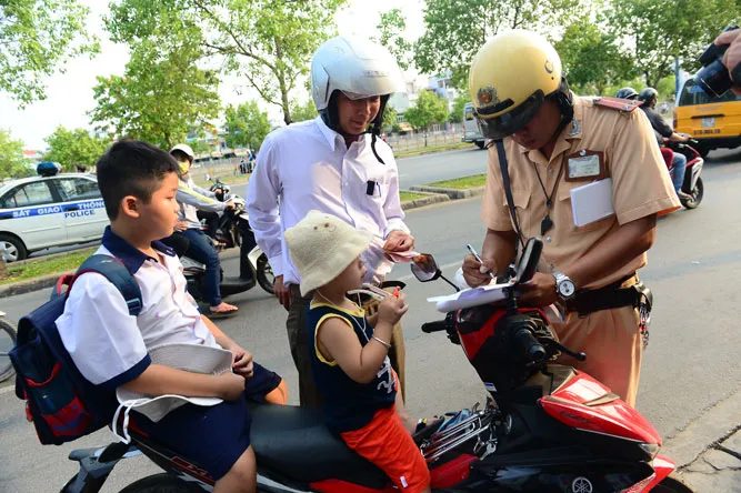 Học sinh đi xe đạp điện không đội mũ bảo hiểm cũng sẽ bị xử phạt. Các trường hợp không mang theo giấy tờ xe hoặc giấy tờ liên quan sẽ bị lập biên bản xử phạt ngay tại chỗ Cảnh sát sẽ tiến hành kiểm tra giấy tờ xe và giấy phép lái xe đối với phụ huynh điều khiển xe và không đội mũ hoặc đội mũ cho con không đúng quy định. Nhiều trường hợp đội mũ những vẫn không gài quai theo đúng quy định. Một phụ huynh đón con chở ba, không đội nón chạy vượt qua chốt lực lượng chức năng khi bị thổi còi yêu cầu dừng xe. Học sinh đi xe đạp điện không đội mũ bảo hiểm cũng sẽ bị xử phạt. Các trường hợp không mang theo giấy tờ xe hoặc giấy tờ liên quan sẽ bị lập biên bản xử phạt ngay tại chỗ Cảnh sát sẽ tiến hành kiểm tra giấy tờ xe và giấy phép lái xe đối với phụ huynh điều khiển xe và không đội mũ hoặc đội mũ cho con không đúng quy định. Nhiều trường hợp đội mũ những vẫn không gài quai theo đúng quy định. Một phụ huynh đón con chở ba, không đội nón chạy vượt qua chốt lực lượng chức năng khi bị thổi còi yêu cầu dừng xe.