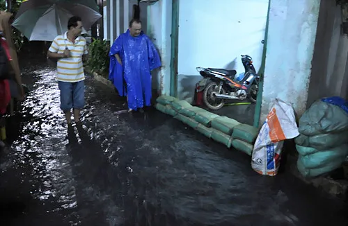 Người dân dùng bao cát đắp đê, be bờ không cho nước tràn vào nhà.