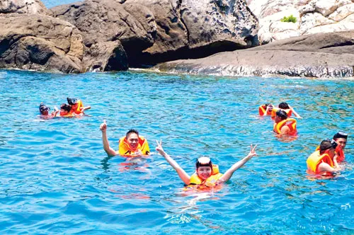 Du khách thích thú với vẻ đẹp hoang sơ của Cù lao Chàm. Hàng ngày có gần 1.000 lượt khách du lịch (ngày lễ lên đến 6.000 lượt khách) ra Cù lao Chàm từ cảng Cửa Đại (Hội An). Một làng chài ven biển làm du lịch. Du khách nước ngoài thưởng thức trái cây vùng nhiệt đới. Du khách lặn xem san hô đỏ. Một góc đảo Cù lao Chàm. Cù lao Chàm có gần 2.500 nhân khẩu, trong đó 50% làm ngư nghiệp phục vụ du lịch. Một quầy hàng lưu niệm.