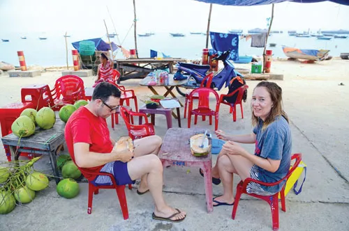 Du khách thích thú với vẻ đẹp hoang sơ của Cù lao Chàm. Hàng ngày có gần 1.000 lượt khách du lịch (ngày lễ lên đến 6.000 lượt khách) ra Cù lao Chàm từ cảng Cửa Đại (Hội An). Một làng chài ven biển làm du lịch. Du khách nước ngoài thưởng thức trái cây vùng nhiệt đới. Du khách lặn xem san hô đỏ. Một góc đảo Cù lao Chàm. Cù lao Chàm có gần 2.500 nhân khẩu, trong đó 50% làm ngư nghiệp phục vụ du lịch. Một quầy hàng lưu niệm.