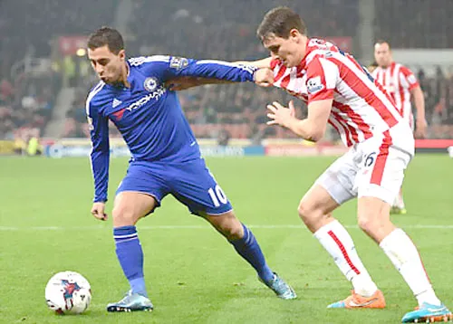 Eden Hazard (trái, Chelsea) che bóng trước Philipp Wollscheid (Stoke City).