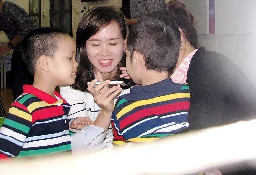 Hai cháu nhỏ này thích thú khi nhìn thấy chiếc điện thoại. Ảnh: Minh Cương