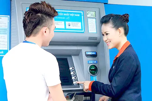 Nhân viên ngân hàng hướng dẫn khách hàng bảo mật trong giao dịch thẻ.