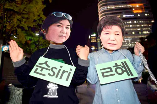 Người biểu tình đeo mặt nạ của Tổng thống Hàn Quốc Park Geun Hye (phải) và "người bạn thân" Choi Soon Sil trong cuộc biểu tình lớn vào ngày 29-10 ở Seoul.