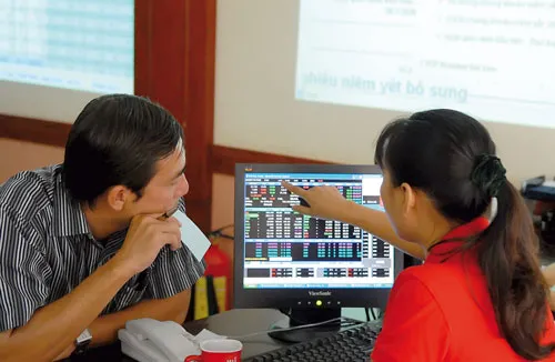 NĐT theo dõi giá CP. Ảnh: CAO THĂNG