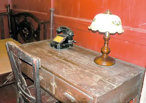 Giường ngủ và bàn làm việc trong phòng trọ của Chủ tịch Hồ Chí Minh ở khu di tích nhà trọ Nam Dương.